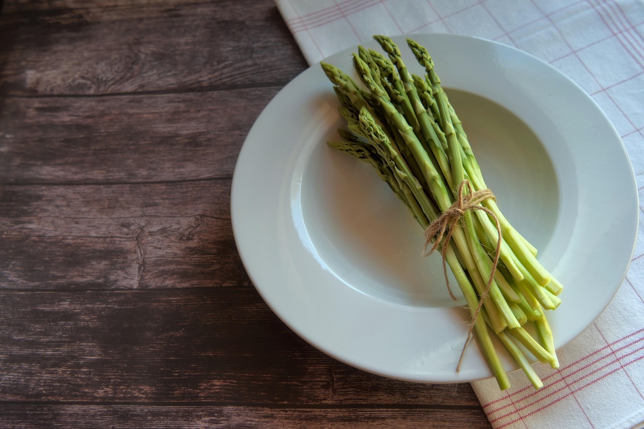 Asparagi freschi cotti al vapore su un piatto, pronti per essere serviti.