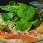 Piatto tipico palermitano con arancine, panelle e sfincione su un tavolo.