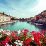Fiori colorati in un campo primaverile italiano con colline verdi sullo sfondo.