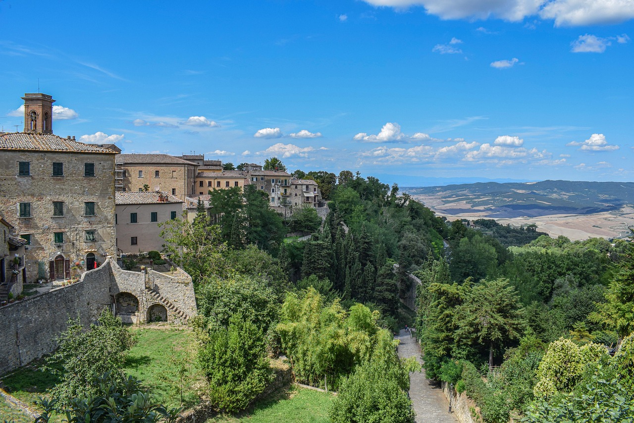 Famiglia di quattro persone esplora un borgo medievale italiano, godendo di panorami e atmosfera storica.